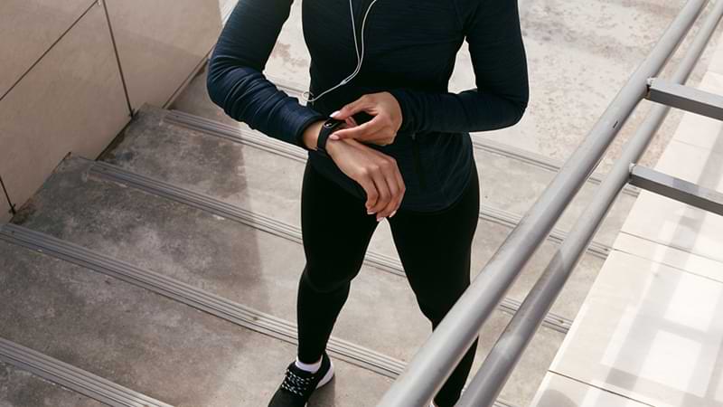 Woman checking target heart rate using digital tracker on wrist