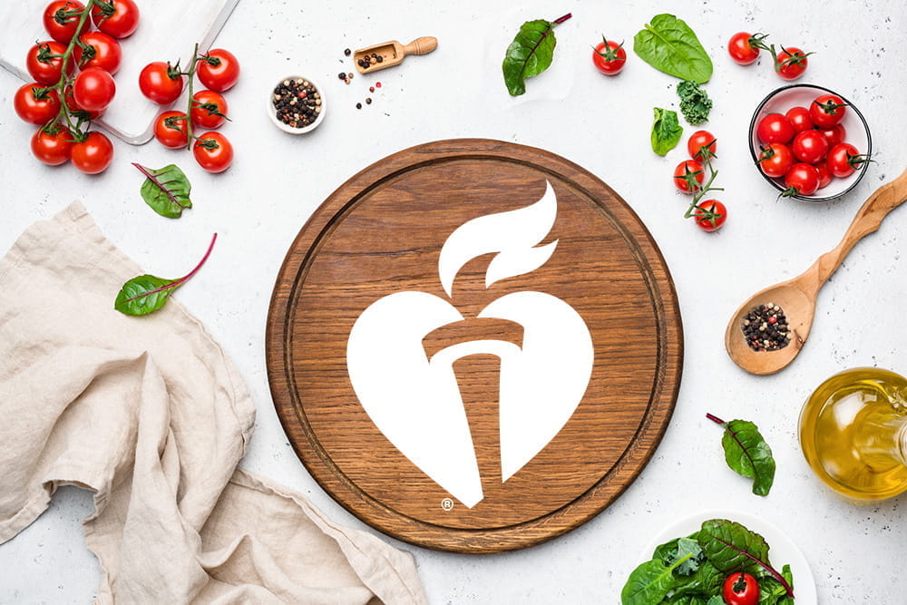 cutting board with aha logo and vegetables