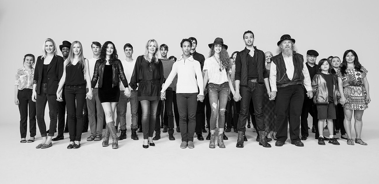 group of people holding hands and standing while looking directly at the camera