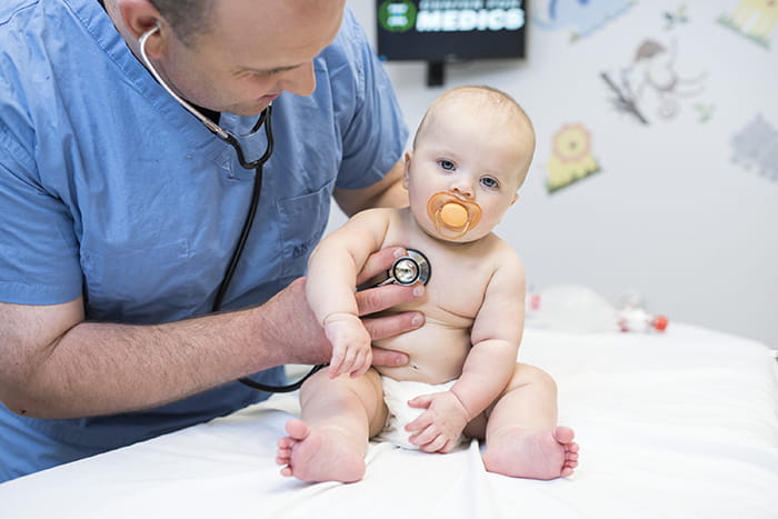 doctor with stethoscope on infants chest