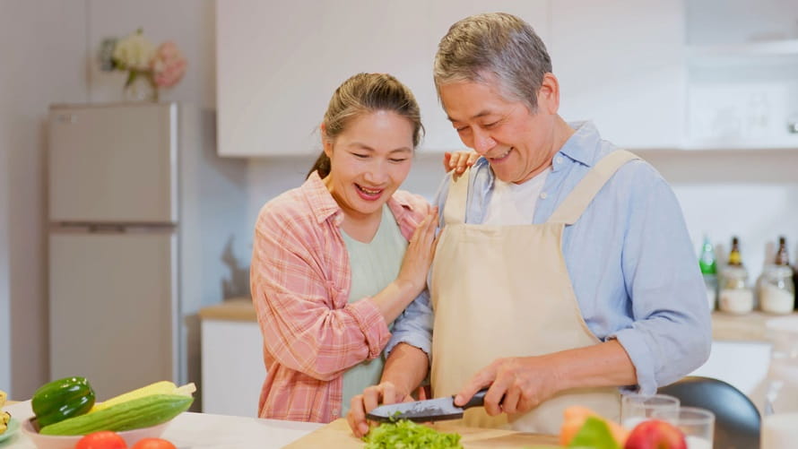 Man and woman chopping vegatables
