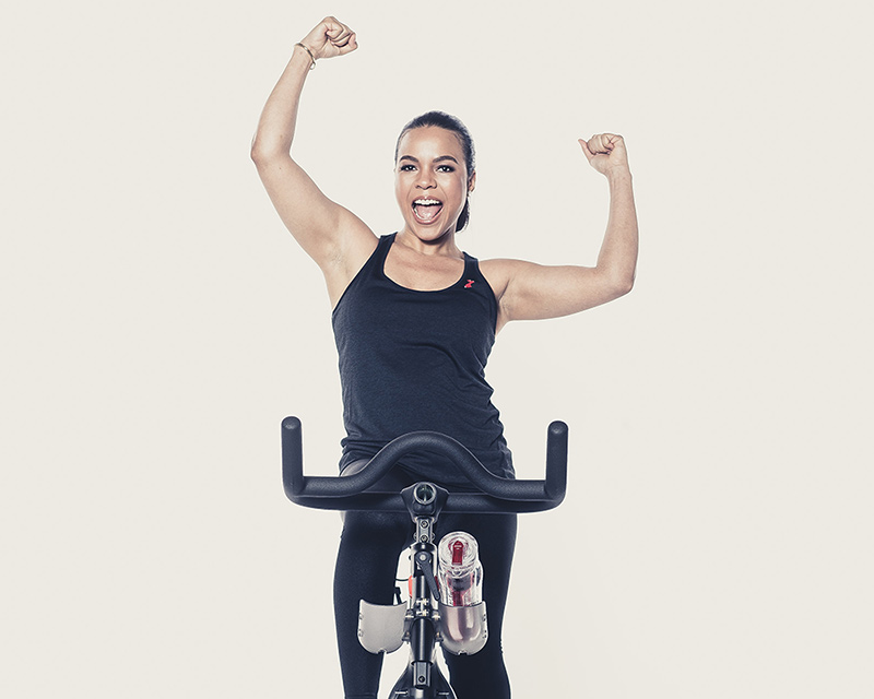 Candy Calderon using an exercise bike and cheering