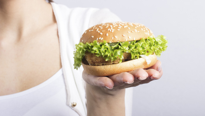 close up of chicken sandwich on a woman's hand