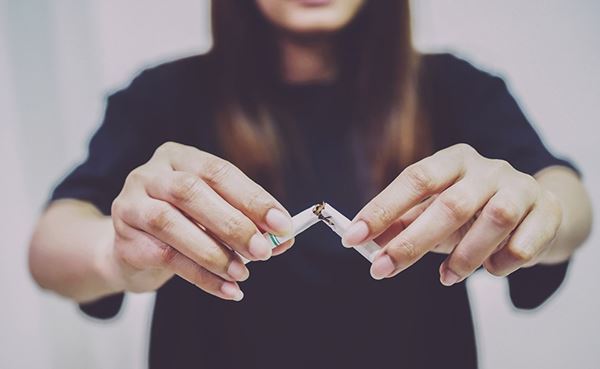 mujer deja de fumar mujer rompiendo un cigarrillo por la mitad
