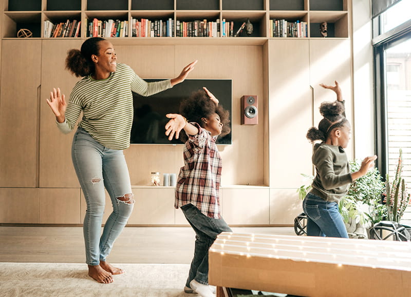 mom dancing with daughters at home