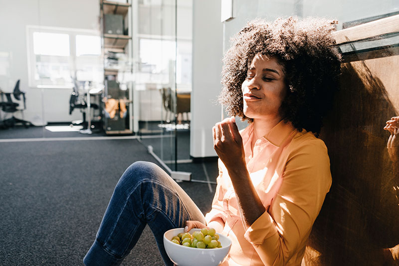 woman snacking in office at work