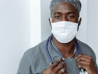 A medical provider wearing a mask looking at the camera