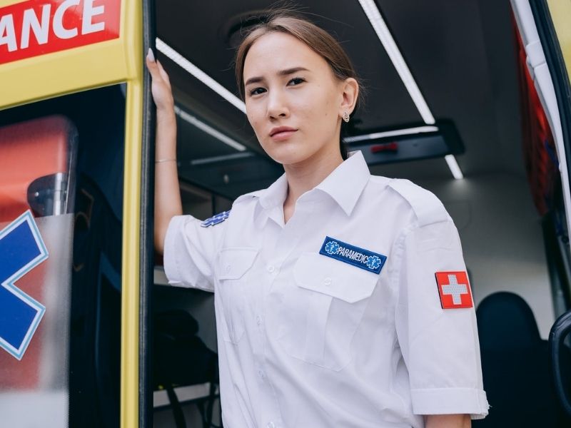 A paramedic leaving an ambulance looking at the camera