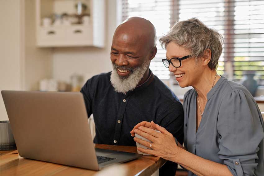 Smiling older couple looking at laptop