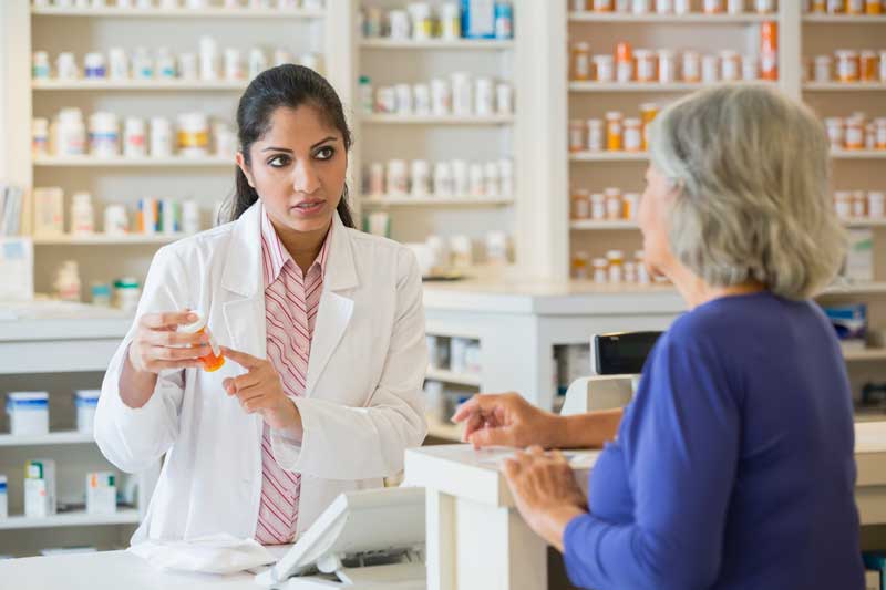 Pharmacist explaining medications to customer