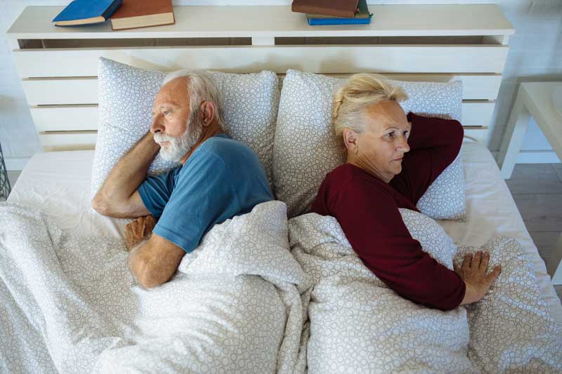 frustrated older couple in bed
