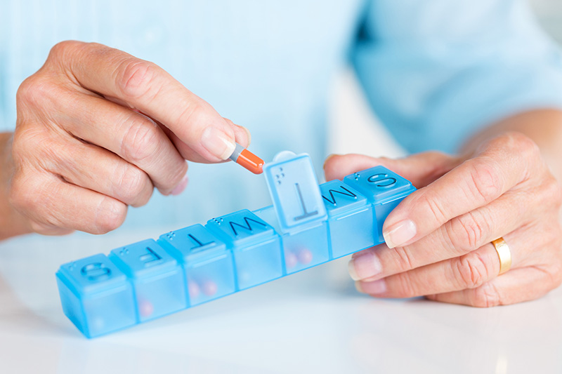 woman hands placing pills in sorter