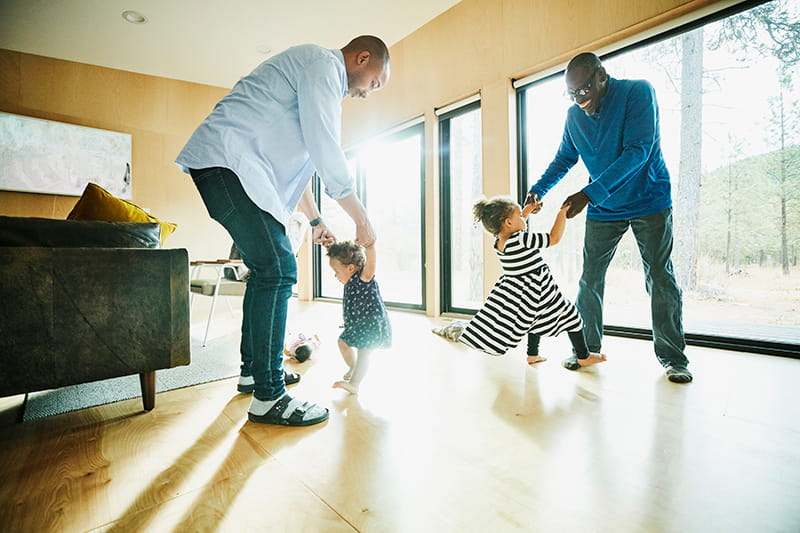 Grandfather father dancing with daughters at home