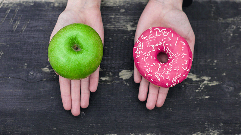 Hands showing choice between an apple or donut