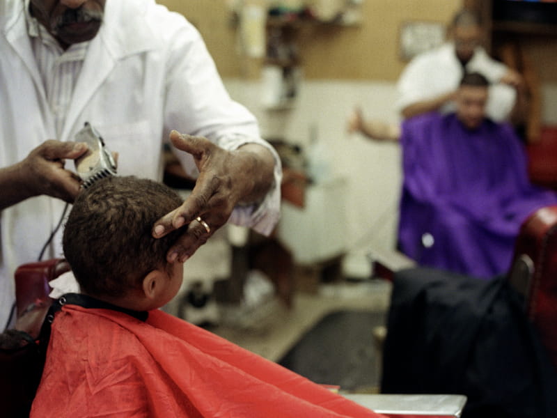 African-American barbers cutting hair.