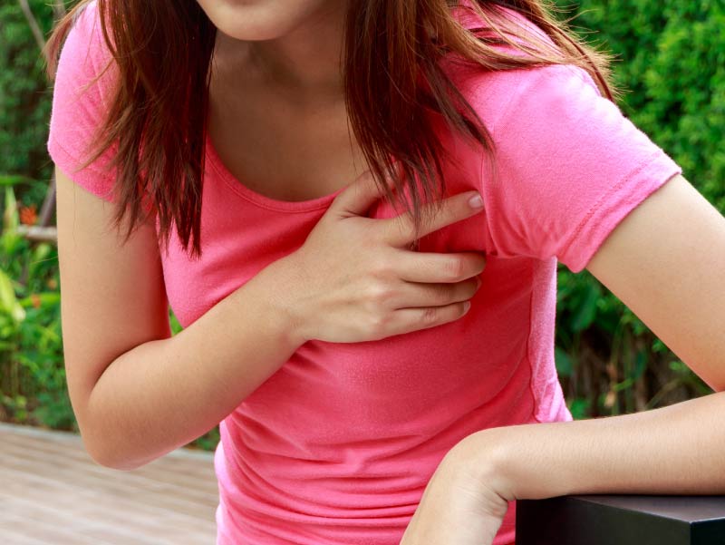 Young woman clutching chest.