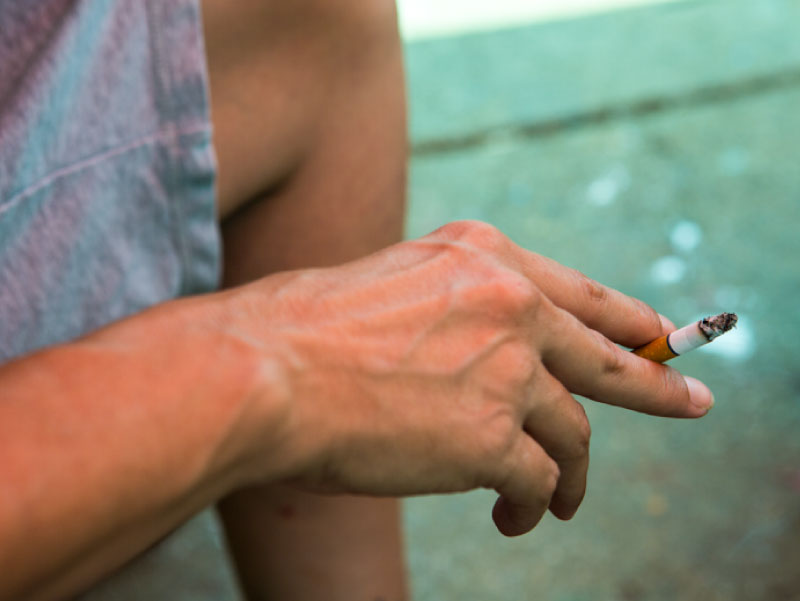 Person's hand holding cigarette. (Amie Vanderford for AHA News)