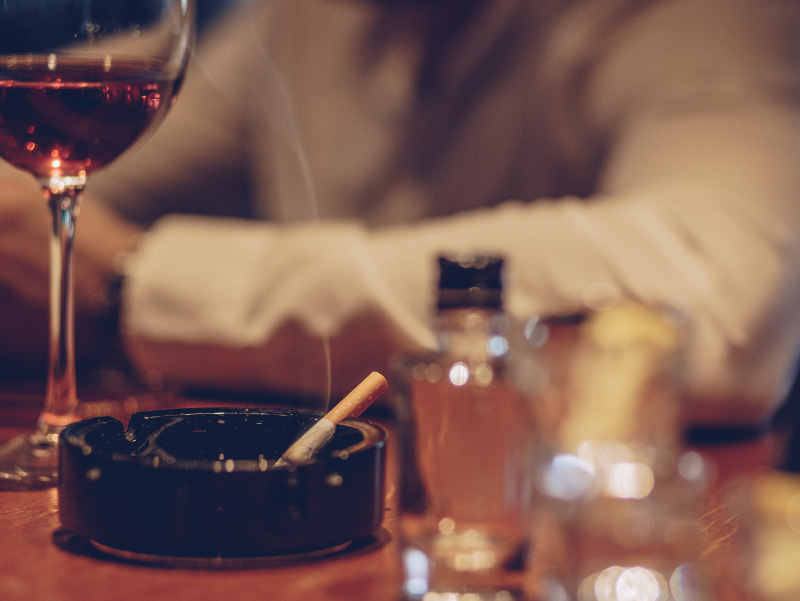 Photo of cigarette and wine glass.