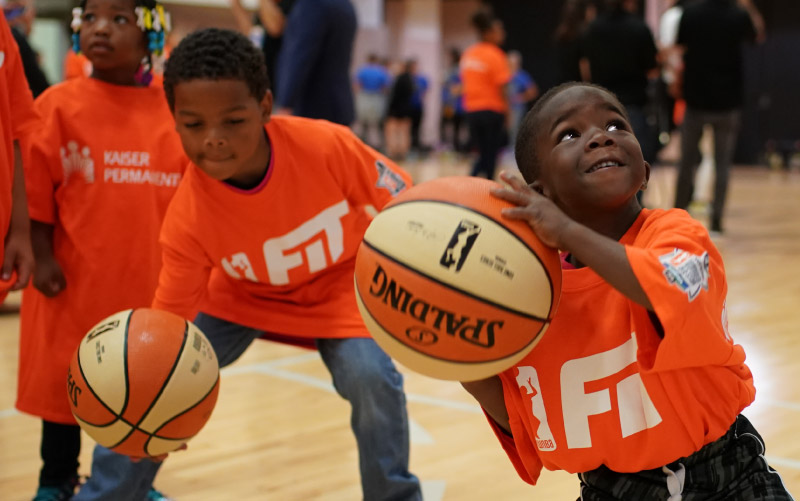 A young boy prepares to shoot a hoop at one of the WNBA's All-Star Fit Clinics. (Photo courtesy of the WNBA)