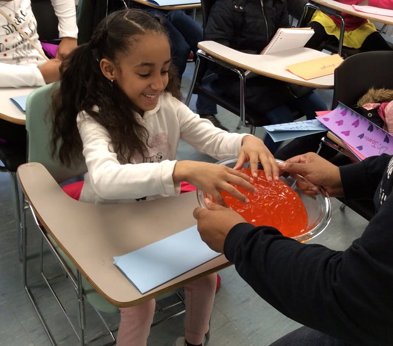 Olivia Matthews (left) examines a brain made from a Jell-O mold, a popular prop used by Dr. Inniss. (Photo courtesy of April Inniss)