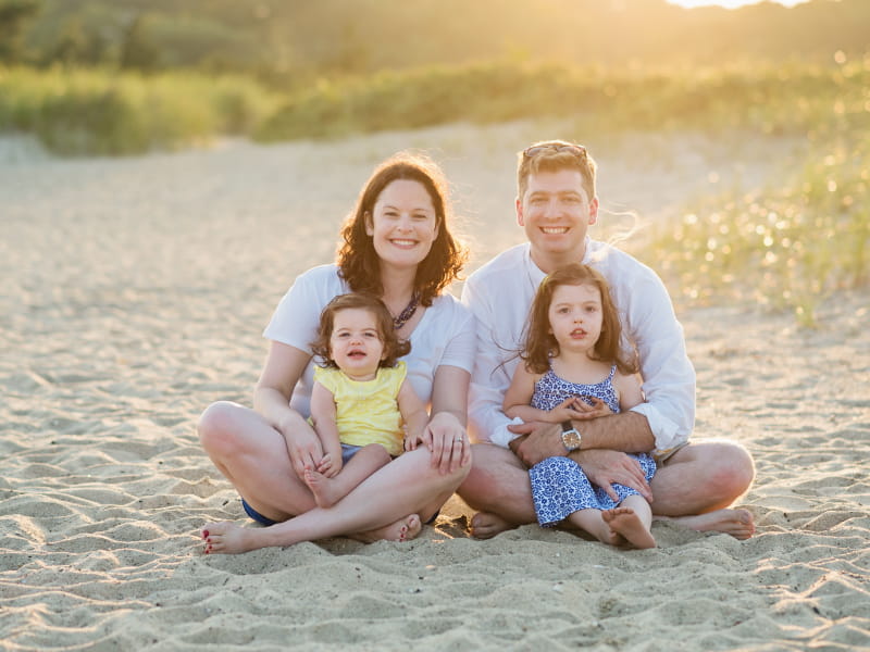 Melissa Russom and her husband, Braden, enjoy a beach vacation with their daughters in Cape Cod. The sisters, Kate (left) and Cora inherited a genetic heart condition called Long QT syndrome. (Photo by Sarah Murray)