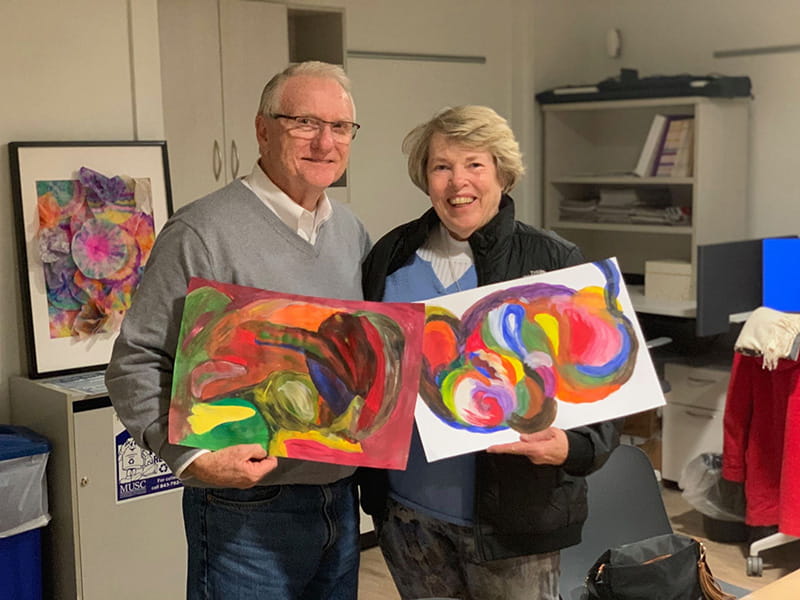 Suzie Hankins (right) and her husband Dan with their artwork from a 'Strokes for Strokes' workshop. Suzie has aphasia after surviving a stroke in 2000 and enjoys participating in the workshops with Dan. (Photo by Sarah Pack, MUSC)