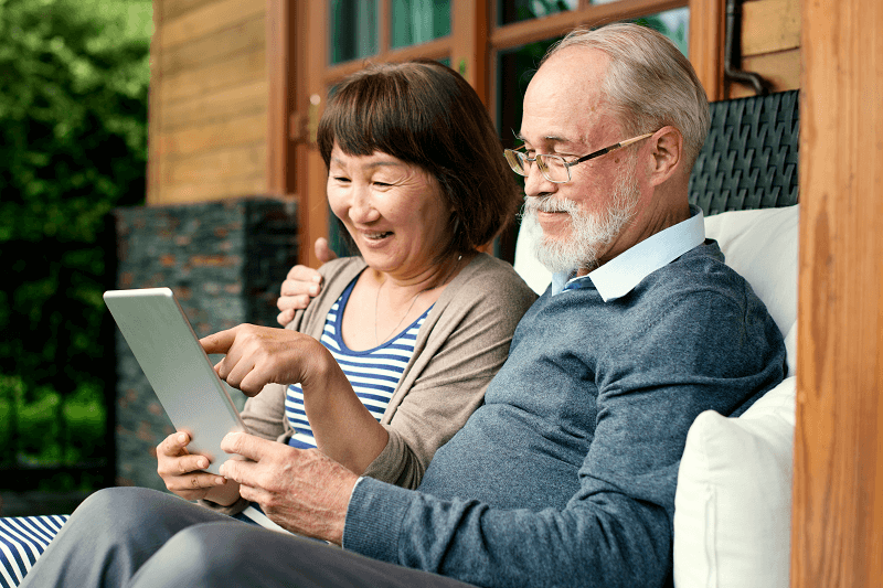 Senior Couple Talking and looking at a tablet