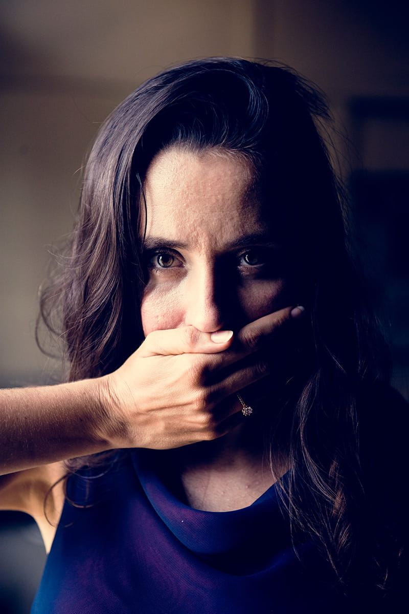 woman with hand covering her mouth