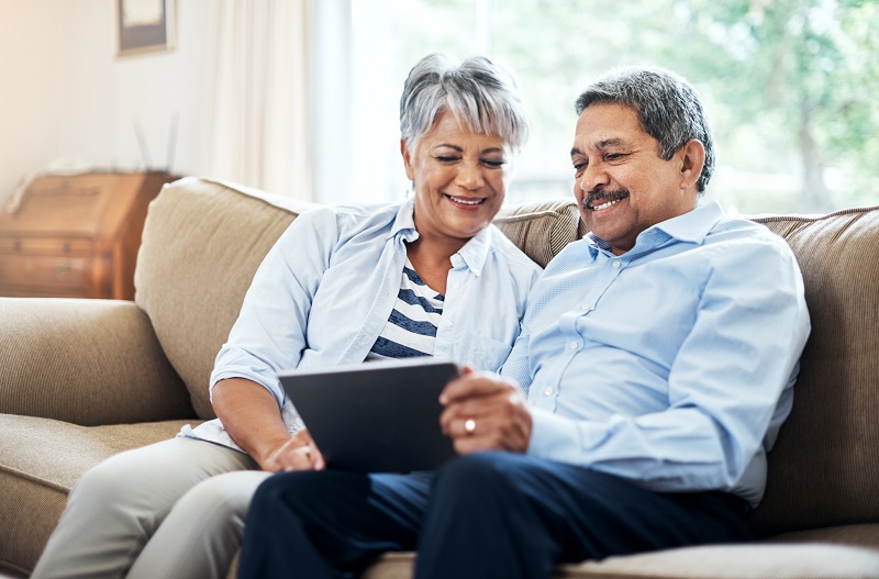 Couple on sofa looking at a tablet