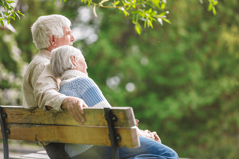 Elderly couple on a bench in a park setting