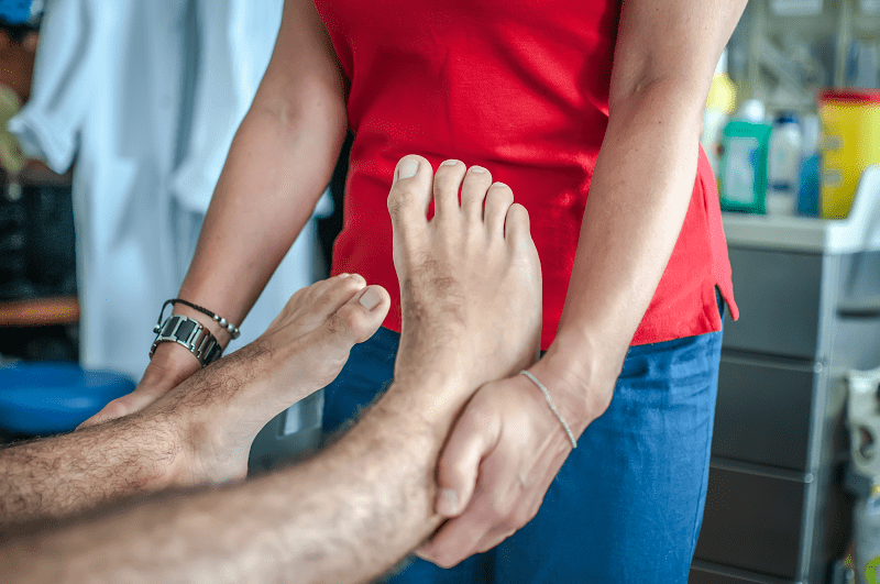 woman positioning a man's foot 