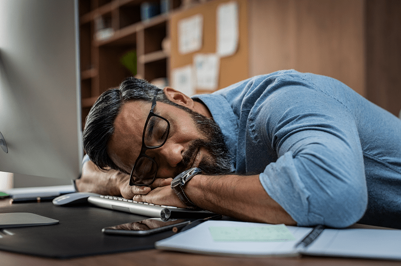 Tired man with head resting on his desk