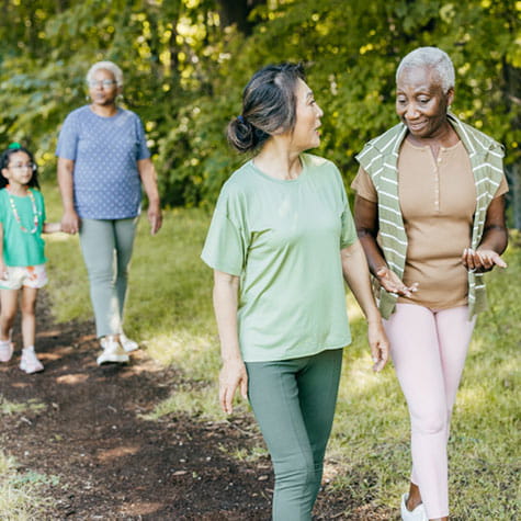 senior women hiking and talking on a dirt trail