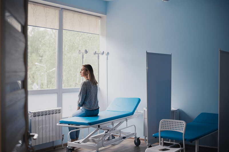 Woman waiting to be seen in a hospital room