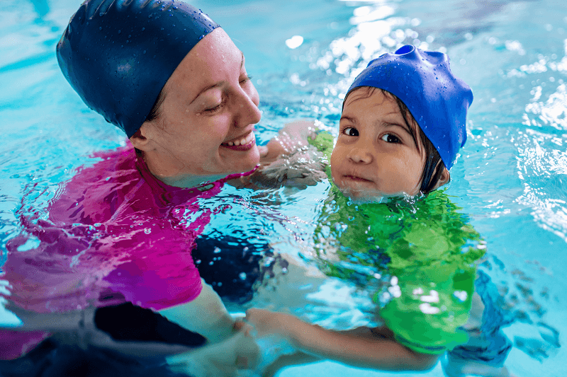 Child in swimming class with adult