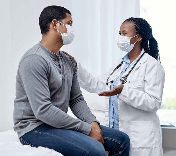 masked male patient and doctor