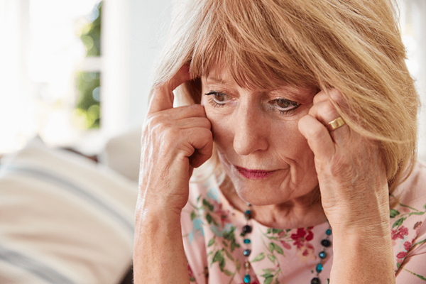 Senior Woman sitting at home with her head in her hands