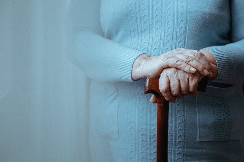 Woman standing with a walking stick in her hand