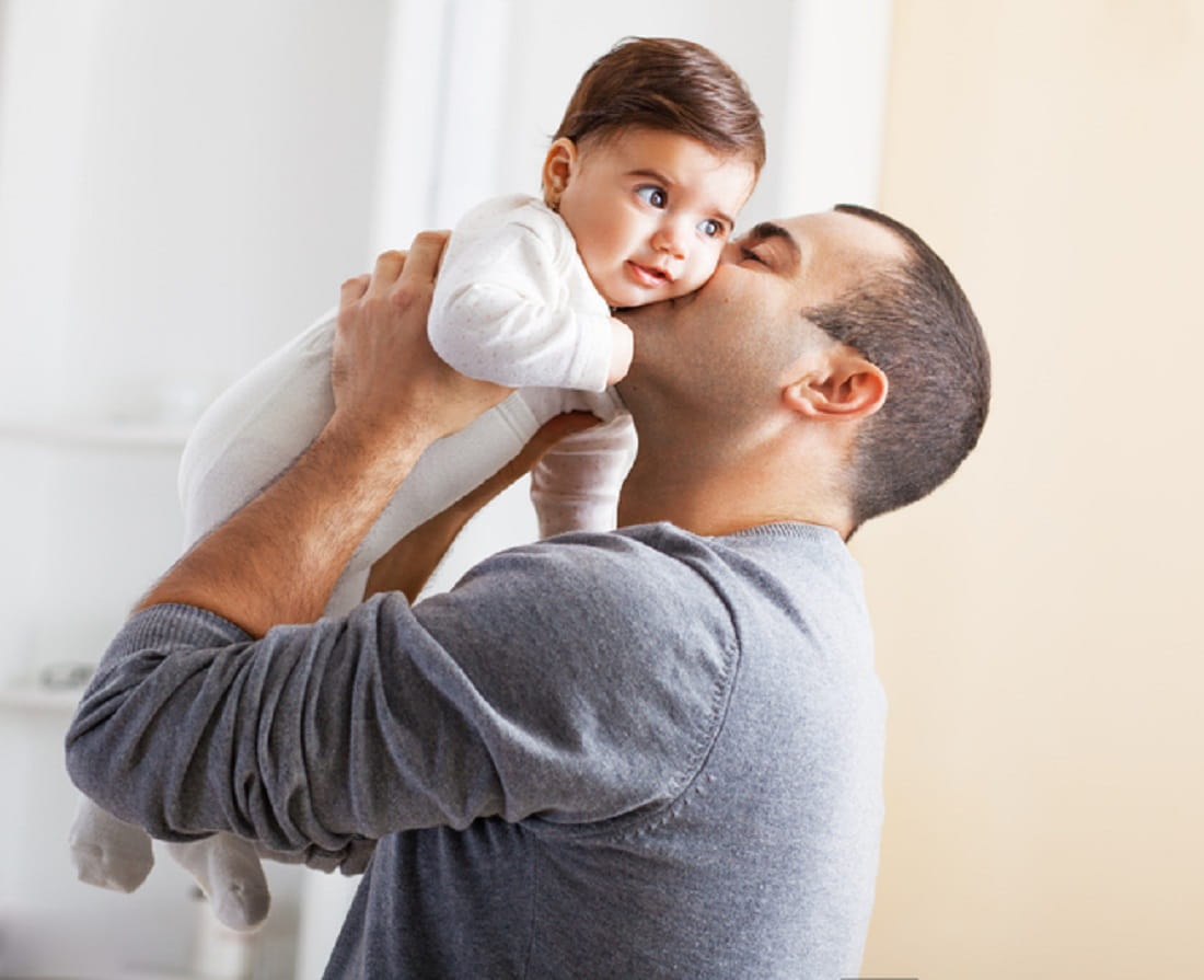 dad kissing newborn