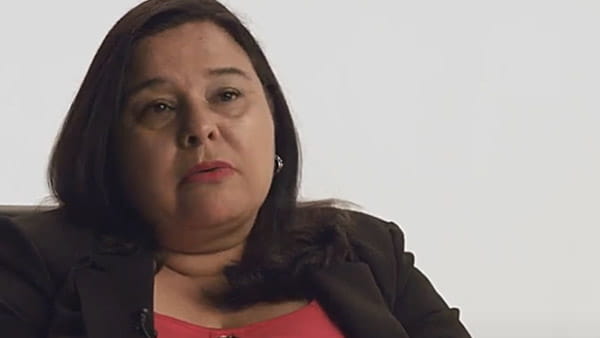 Captura de pantalla de un video de Marissa Ulloa, sobreviviente de un ataque o derrame cerebral, sentada en una silla frente a un fondo neutro