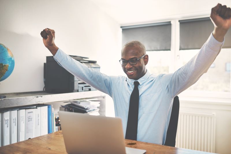 man raising arms in victory