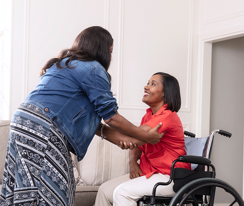 Woman receiving assistance in a wheelchair