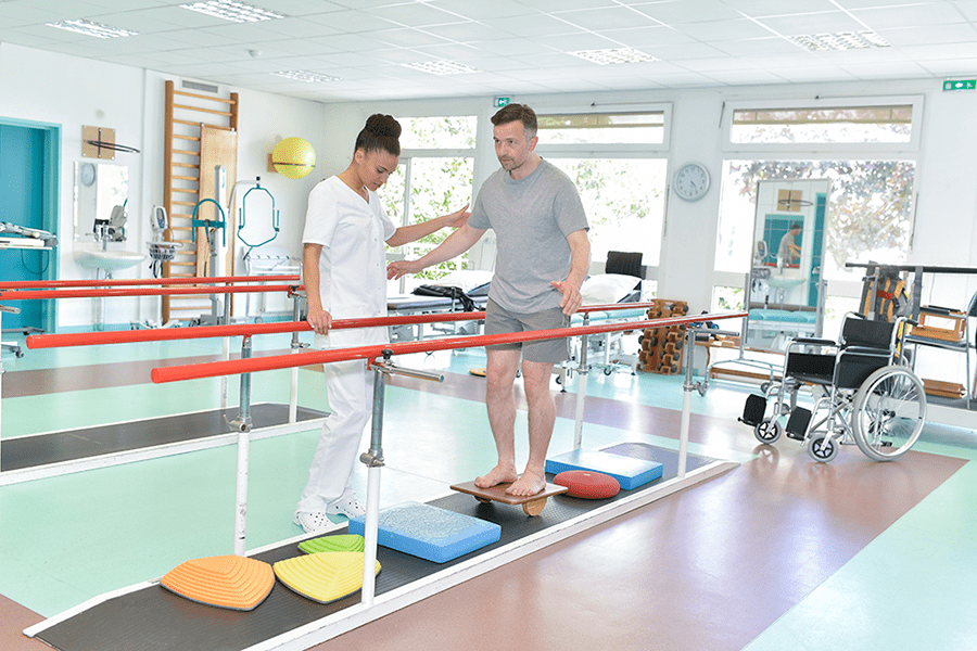 Man balancing with physiotherapist
