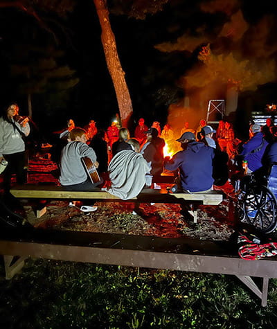a group of people around a campfire at night