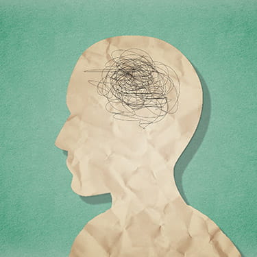 a digital illustration of a paper head silhouette on a green background with a black scribbled mass for the brain