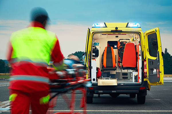 Emergency medical service personnel rushing a patient to an ambulance