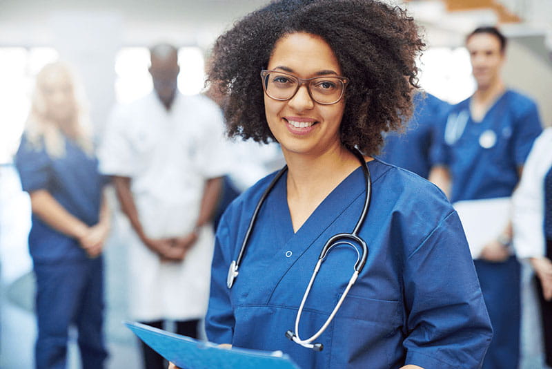 female doctor standing in a clinic with other healthcare professionals