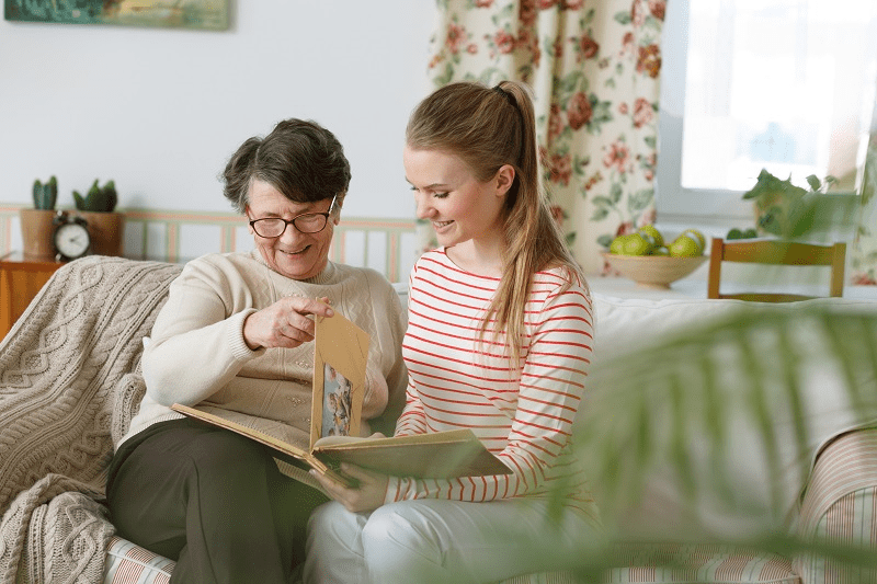 	grandma and granddaughter looking at photo album