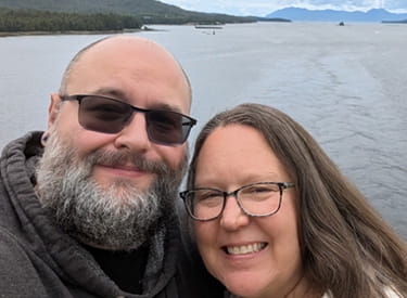 Un selfi del sobreviviente de ataque o derrame cerebral, Chris Rose, y su esposa con el agua y montañas de fondo