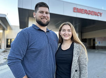 Whitney Sheffield and her husband are standing in front of Brigham City Community Hospital's emergency entrance (photo credit: HCA Healthcare)